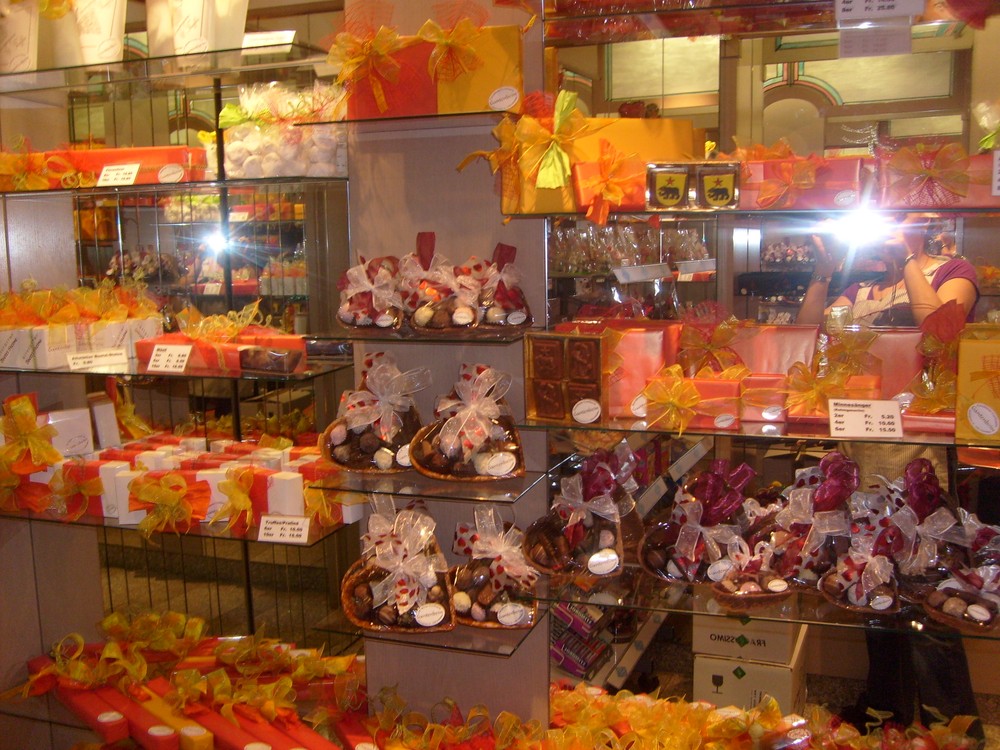 Confiserie-Regal voller verpackter Pralinés und Geschenke